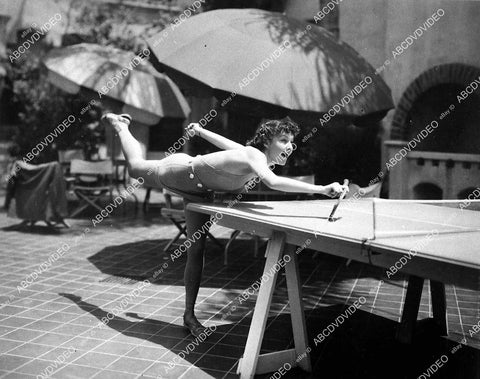 Lynn Bari stretched out in new swimwear playing ping pong - 11007-032