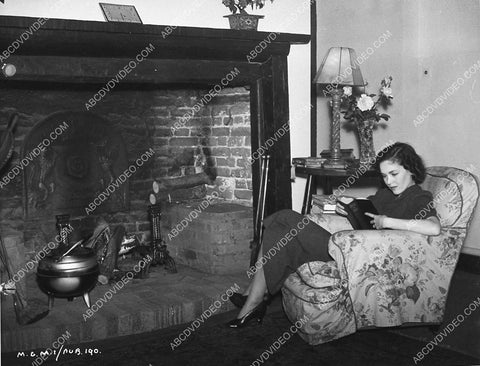 Maureen O'Sullivan takes in a good book by the fireplace 988-18