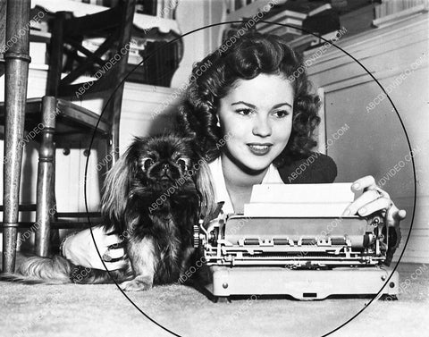 candid Shirley Temple and her dog lay down at the typewriter 1032-12