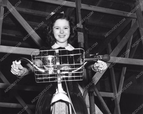 candid Shirley Temple on her bicycle on the studio backlot 1208-25