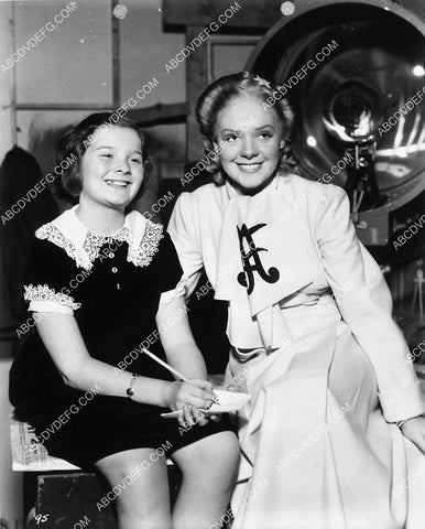 some girl taking notes on set w Alice Faye 1921-12