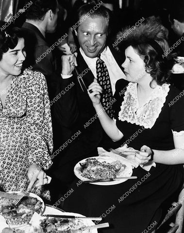 hostess Bobby Fiddler watches Harry Ritz clown w Judy Garland at dinner party 2350-34