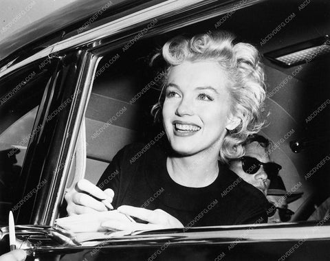 candid Marilyn Monroe signing autograph from automobile 4544-36