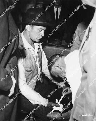 candid Gary Cooper getting his thumb bandaged on set film Man of the West 6943-003