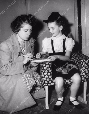 candid Margaret O'Brien learning how to use some kind of knitting device 8969-34