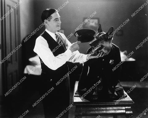 some actor posing w his German Shepherd dog in a police uniform 9482-35