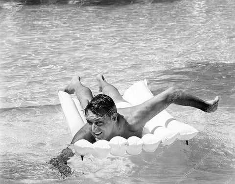 Cary Grant in swim trunks getting some sun in the pool 8b20-14730