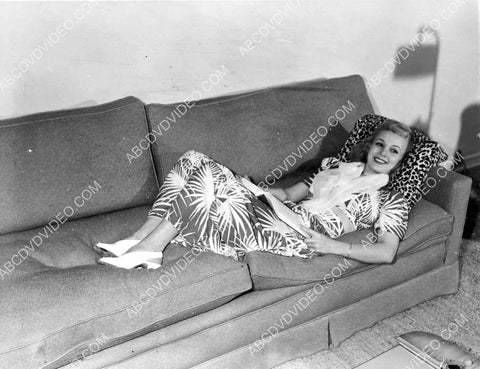 candid Carole Landis laying on the sofa reading a book 8b20-17069