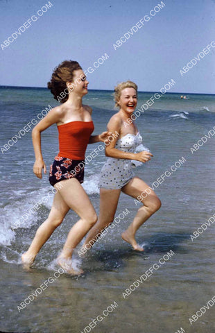 Lee Remick and friend running down the beach 8b20-20532