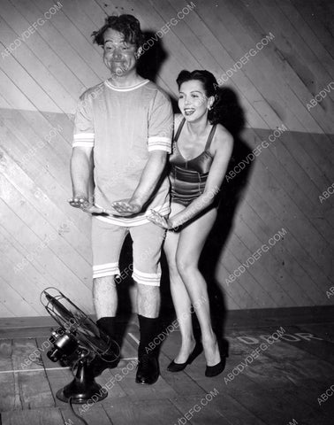 Red Skelton Ann Miller cool off in front of a fan behind the scenes dp-2384