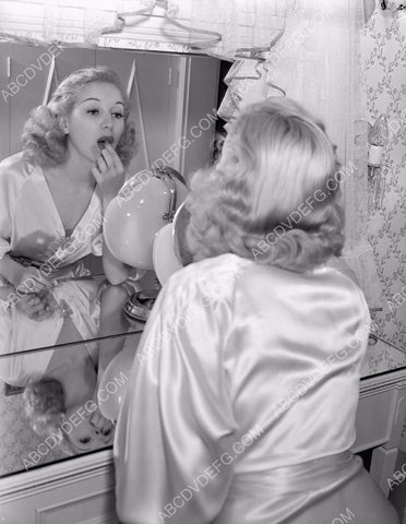 Betty Grable applies some lipstick at her makeup table 8b20-4843