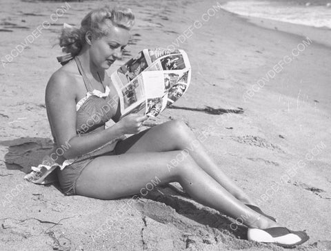 Betty Grable reads the newspaper on the beach 8b20-4852
