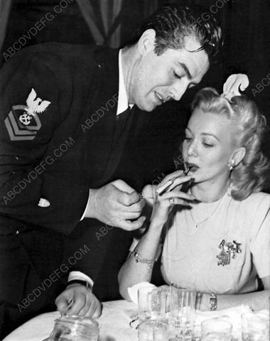 candid Victor Mature gives Carole Landis a light 8b20-6875