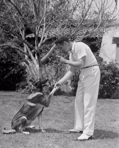 Dick Powell plays with his dog in the backyard 8b20-8249