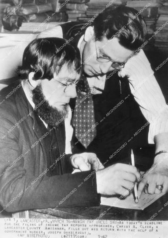 crp-14248 1942 news photo IRS agent Joseph Oaks helps Amish man Christ A Glick fill out income tax forms crp-14248