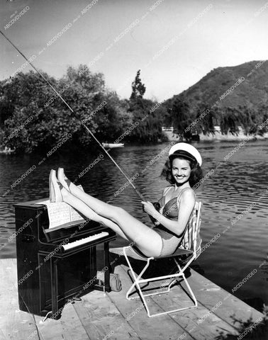 crp-15104 1941 sexy Janet Blair stretches legs on miniature piano while fishing vintage pinup pose crp-15104