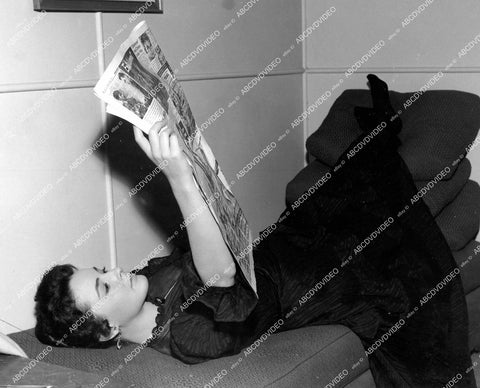 crp-18262 1955 pretty Jeanette Sterke relaxing between scenes reading newspaper film The Prisoner crp-18262
