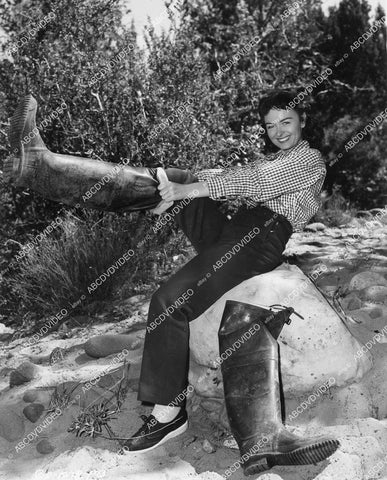 crp-02082 1953 Donna Reed strapping up her thigh high fishing boots on location film Gun Fury crp-02082