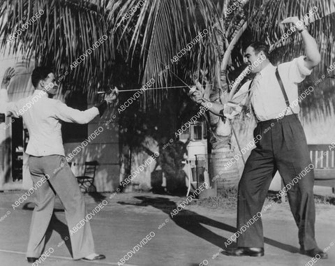 crp-00867 1936 boxer Primo Carnera crosses foils w Capt St Maurice fencing instructor Roney Plaza Sun Club Miami Fla crp-00867